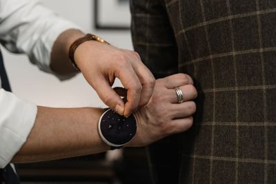 A checked blazer being pinned at the sleeve during a fitting