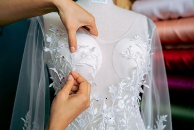 Lace being stitched onto ivory bridal fabric